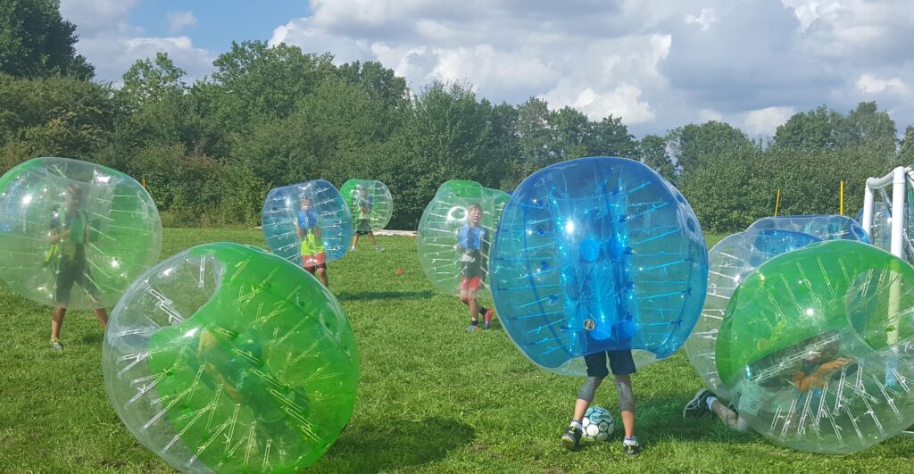 Fußball, Team, gemeinsam am Ball, Lachmusklen, große Bälle, Bubbles